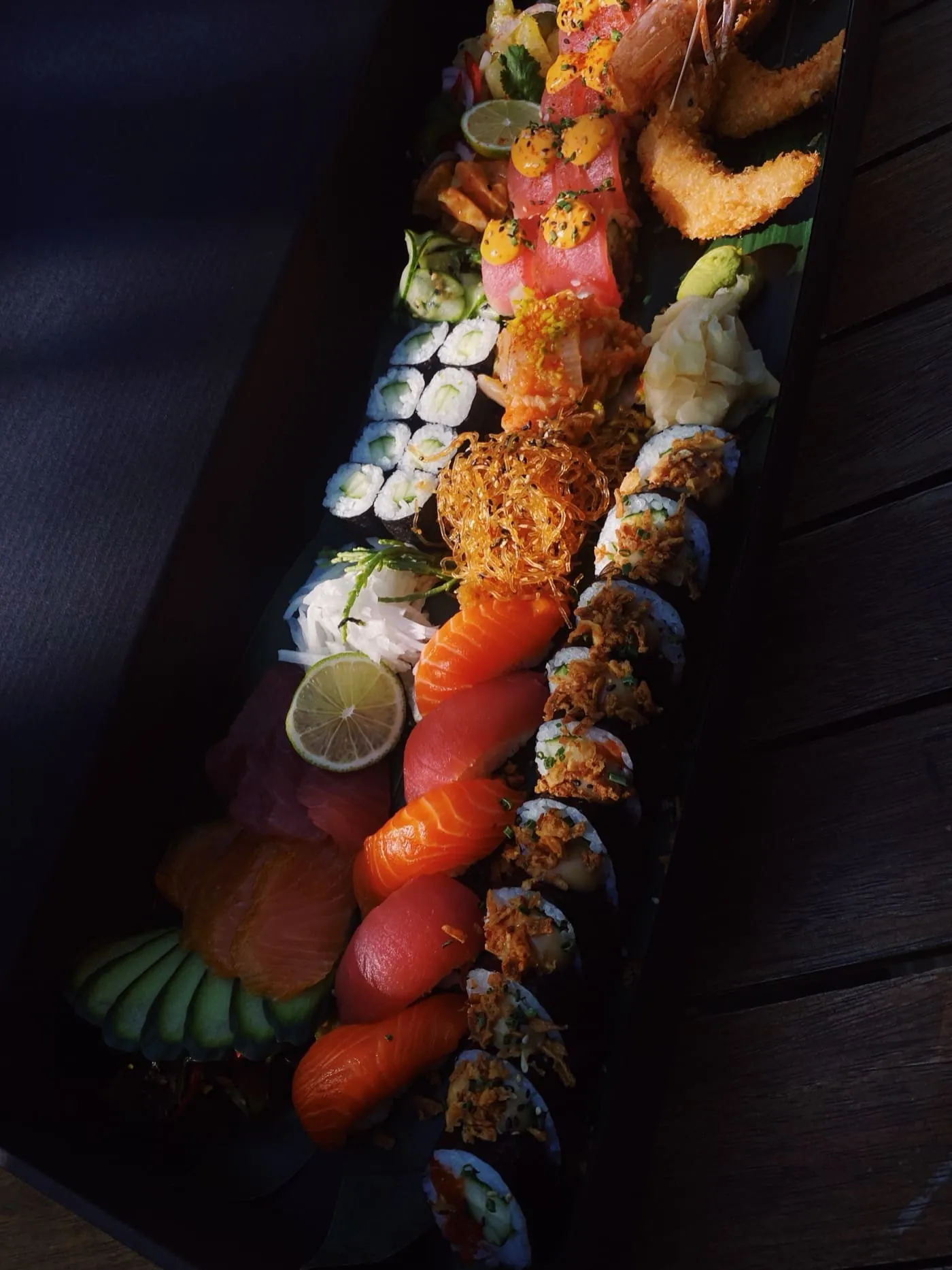 Nigiri, Maki und Rolls auf einer langen schwarzen Platte