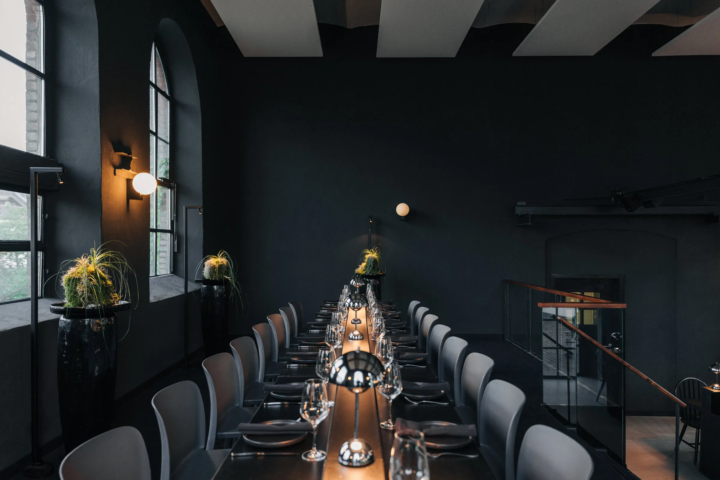 Studio des LAB mit langer schwarzer Tafel und warm leuchtenden Tischlampen