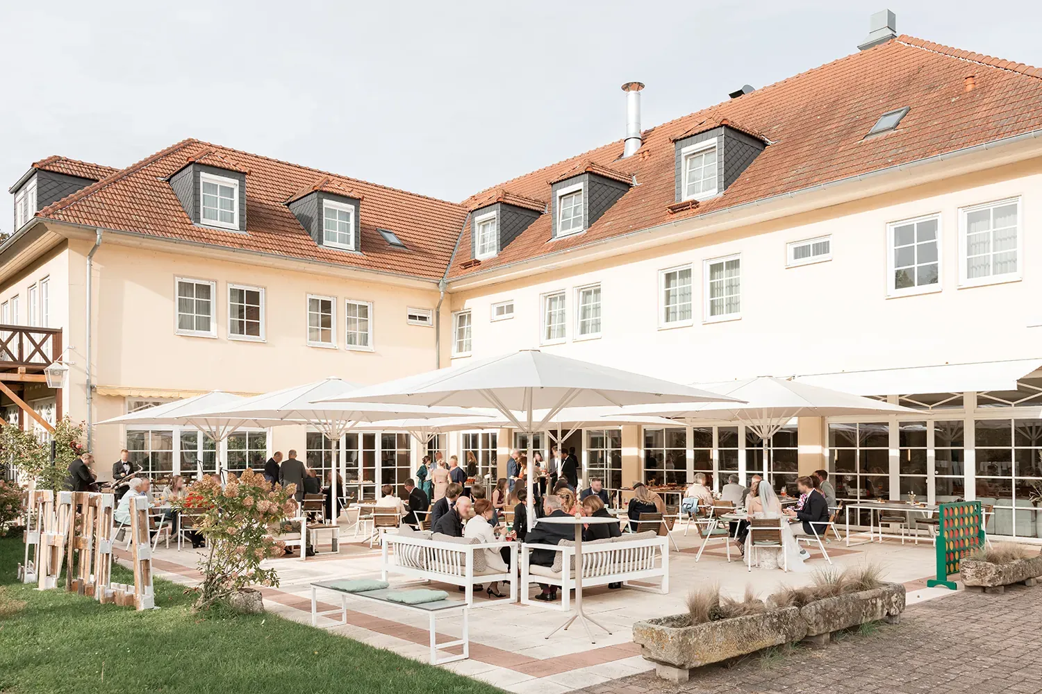 Hochzeitsgesellschaft auf der Schlossterrasse unter weißen Sonnenschirmen